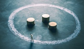miniature figure businessman walking around outside chalk circle with coin